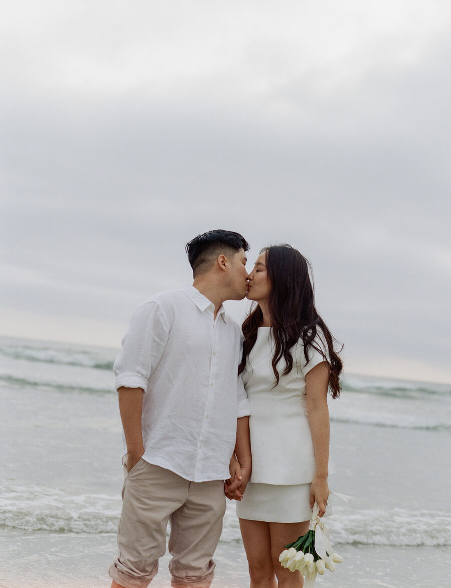 Alice and Matthew kissing on the beach